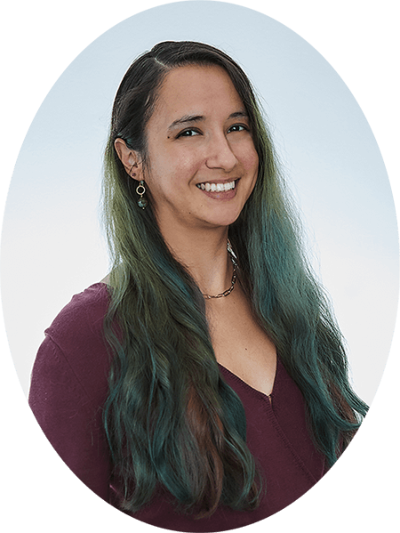 Professional photo of a smiling latina woman with long dark green hair